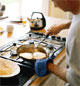 1990's man preparing food on a gas stove